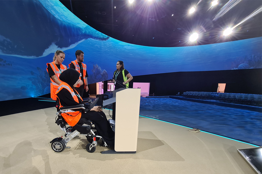 A wheelchair user testing out stage equipment with Cop28 teams
