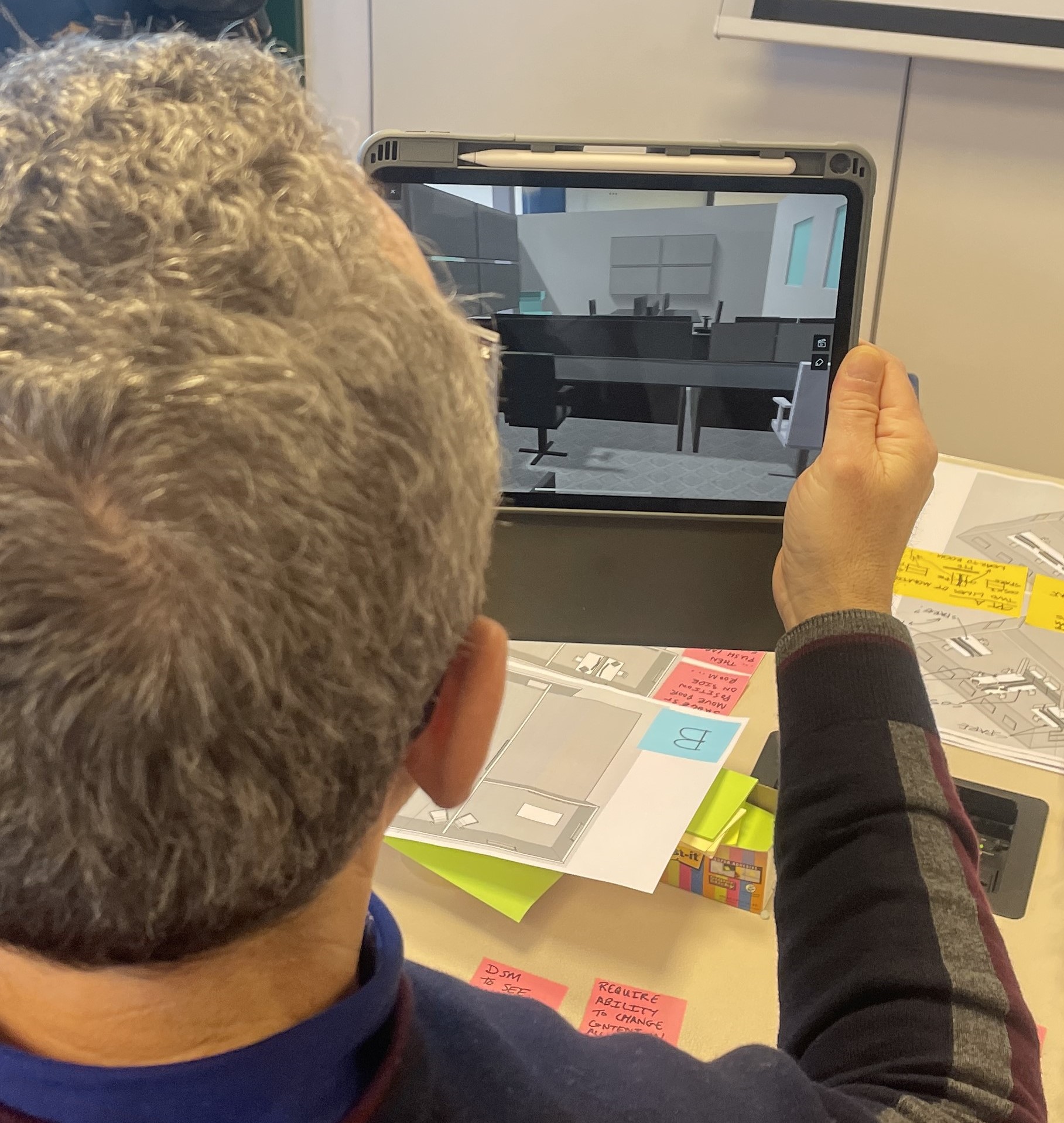 A member of the Bologna Airport team holding up a tablet displaying an augmented reality visualisation of operations concepts for the airport