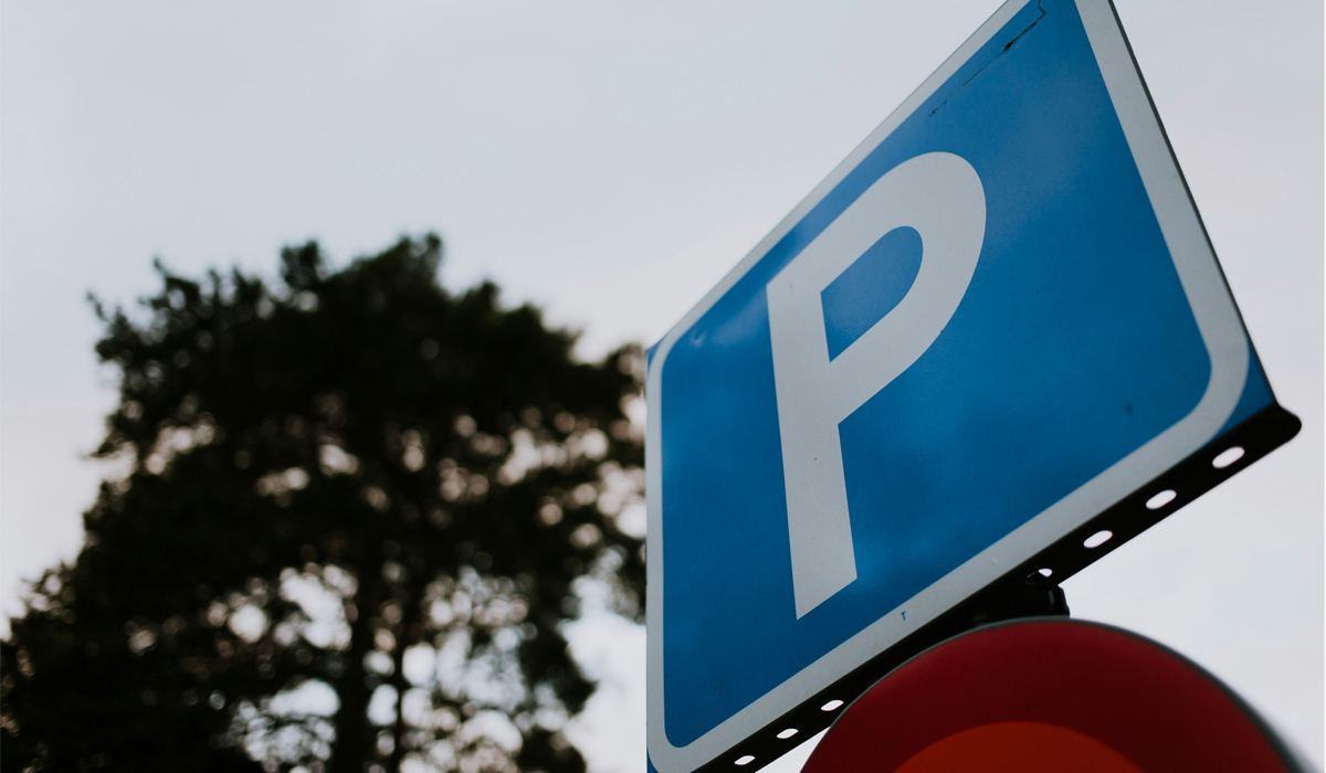 A blue sign with a P in white within a parking area