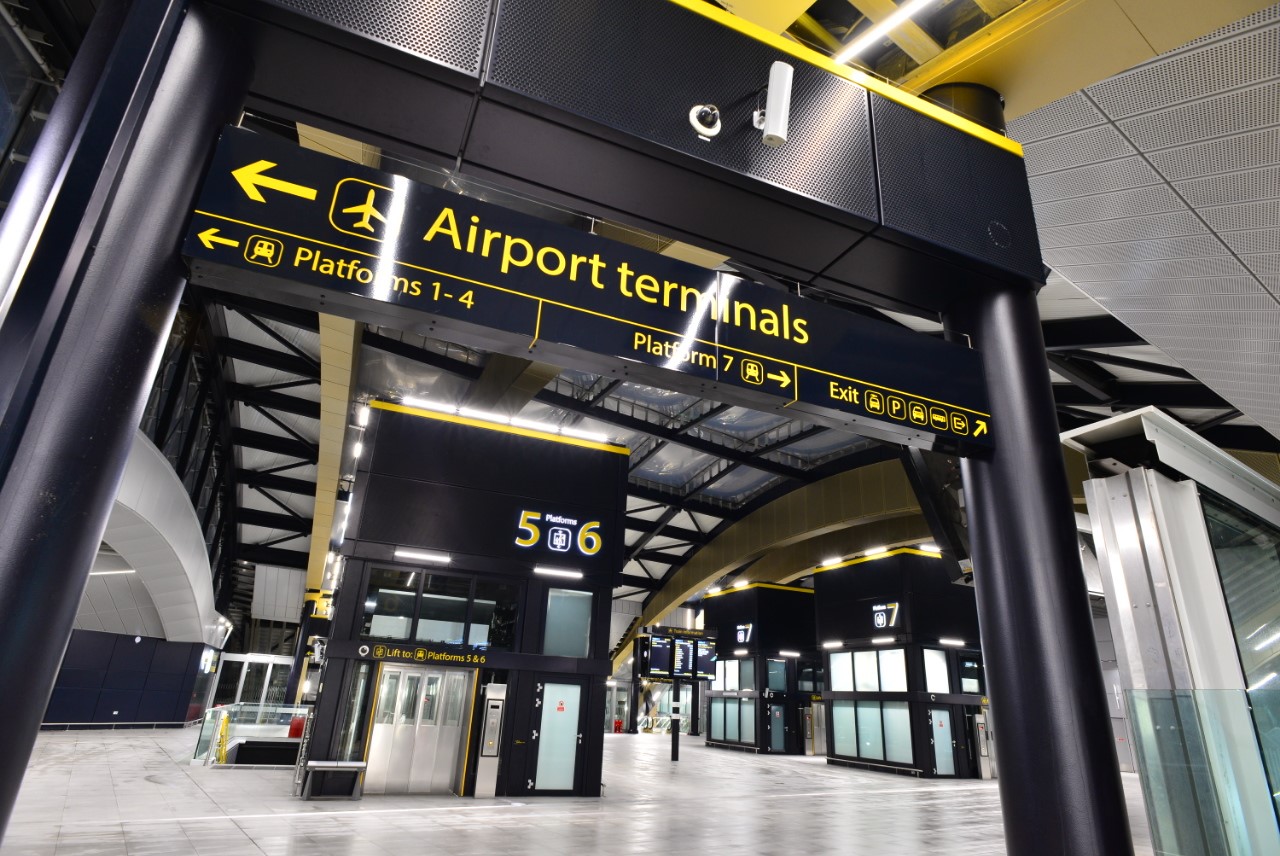 A photo of the the lift at Gatwick airport station with clear signage for airport terminals and the train platforms