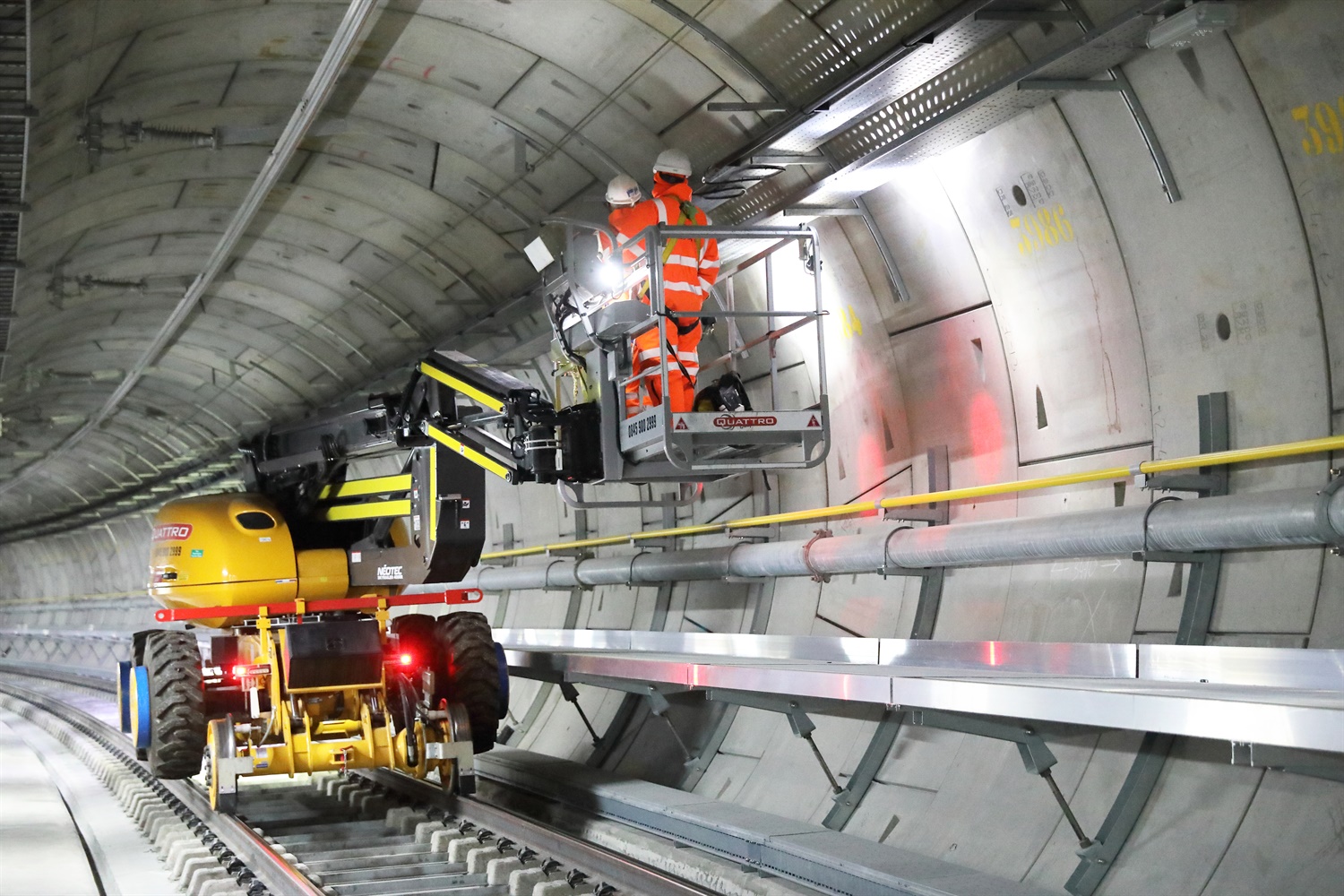 A team of engineers work on installing the Crossrail signalling system in a tunnel