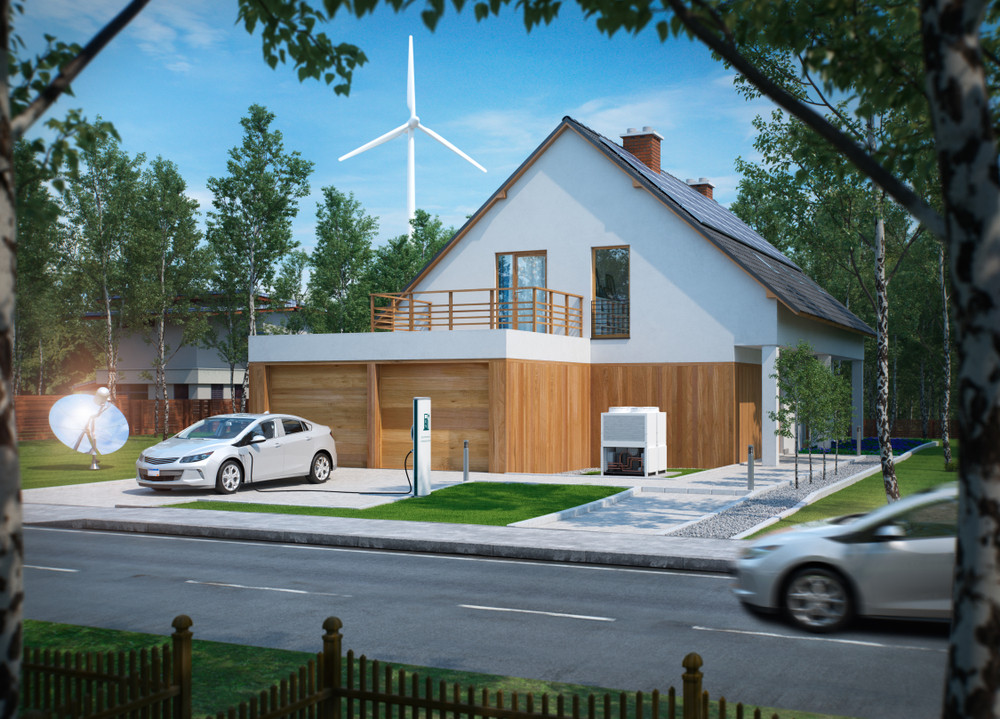 A house complete with electric vehicle charging and wind power turbine in the background